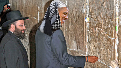 JERUSALEM, ISRAEL - JULY 24: In this handout photo provided by the Ministry of Foreign Affairs (MFA), presumptive Democratic presidential candidate Sen. Barack Obama (D-IL) places a note between the ancient stones  of the Western Wall, as the rabbi of the holy place Shmuel Rabinowitz looks on, before dawn July 24, 2008 in Jerusalem's Old City. Obama visited Judaism holiest site after a day in Israel and the West Bank and before taking off for Germany. (Photo by Avi Hayon/MFA via Getty Images) *** Local Caption *** Barack Obama;Shmuel Rabinowitz