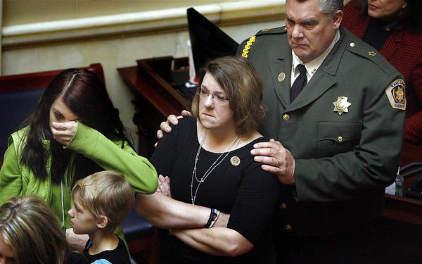 Kane County Sheriff Lamont Smith, right, comforts Shawna Harris and her daughters Kirsten, 14, and Kristina, 10, on Wednesday. State legislators held a moment of silence Wednesday for three Utah Sheriff officers killed in the line of duty last year. Laura Seitz, Deseret News