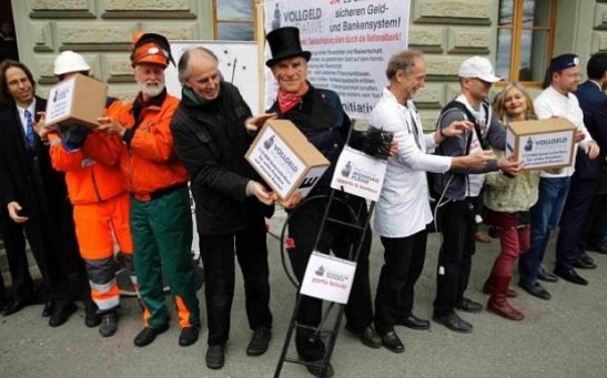 Members of the initiative committee for Monetary Reform (Vollgeld-Initiative) hand over boxes with more than 120,000 signatures at the Federal Chancellery in Bern, Switzerland.